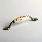 Puxador Metal e Porcelana Marfim Des Dourado 96mm - C1574